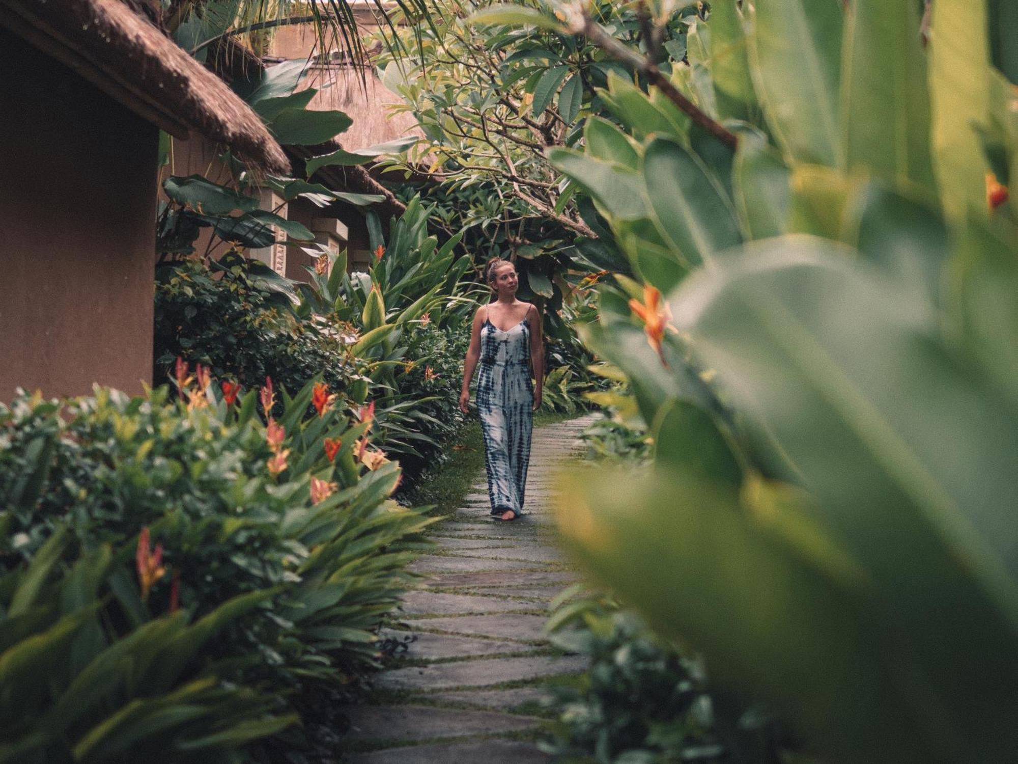 우붓 뉴 발리 리조트&스파 외부 사진 A woman walking through a garden